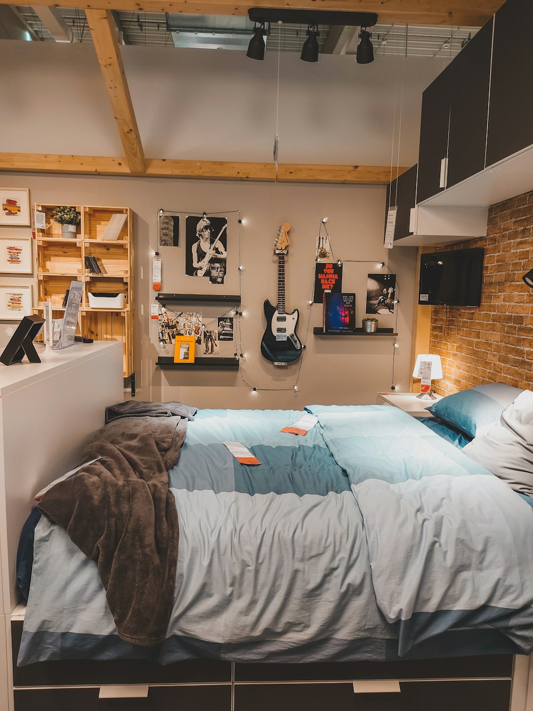services-img a-bed-room-with-a-neatly-made-bed-and-a-guitar-on-the-wall-uzdu1zi4i-m