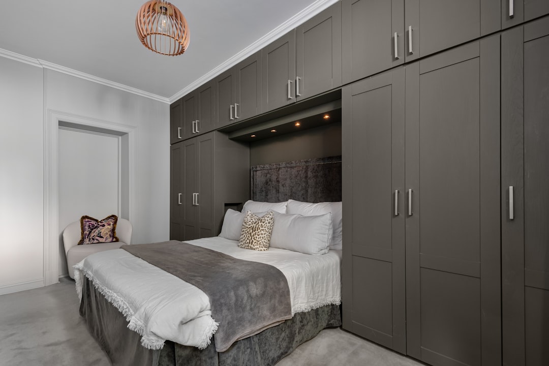 a-bedroom-with-a-bed-cabinets-and-a-chandelier-uz89hwfiwps